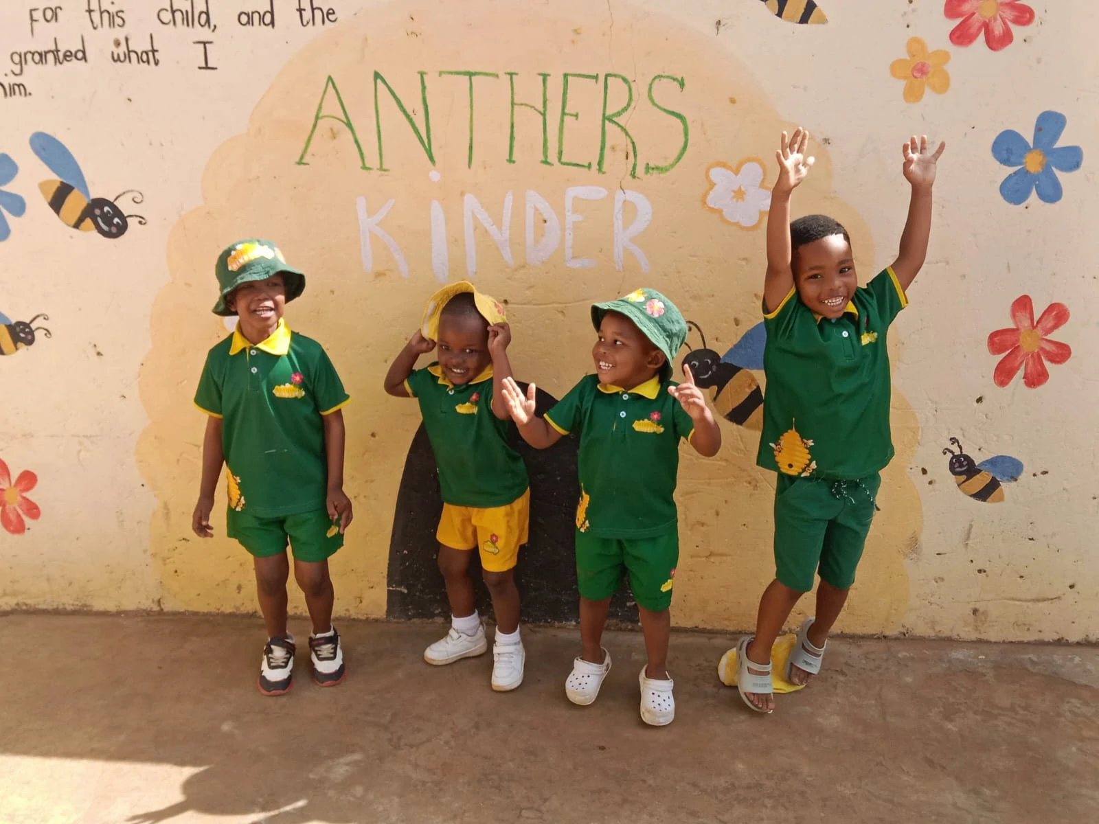 Anthers Kinder pupils smiling together in their green and yellow school uniforms