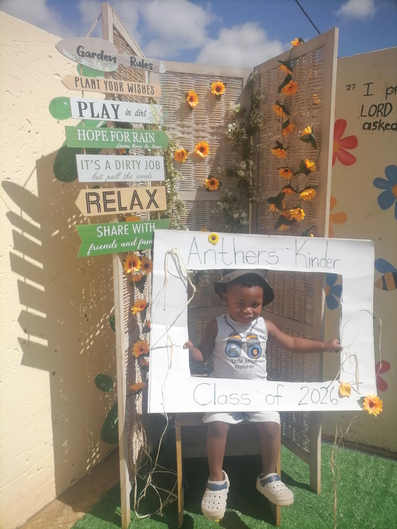 A young pupil in a hat holding the Anthers Kinder celebration frame
