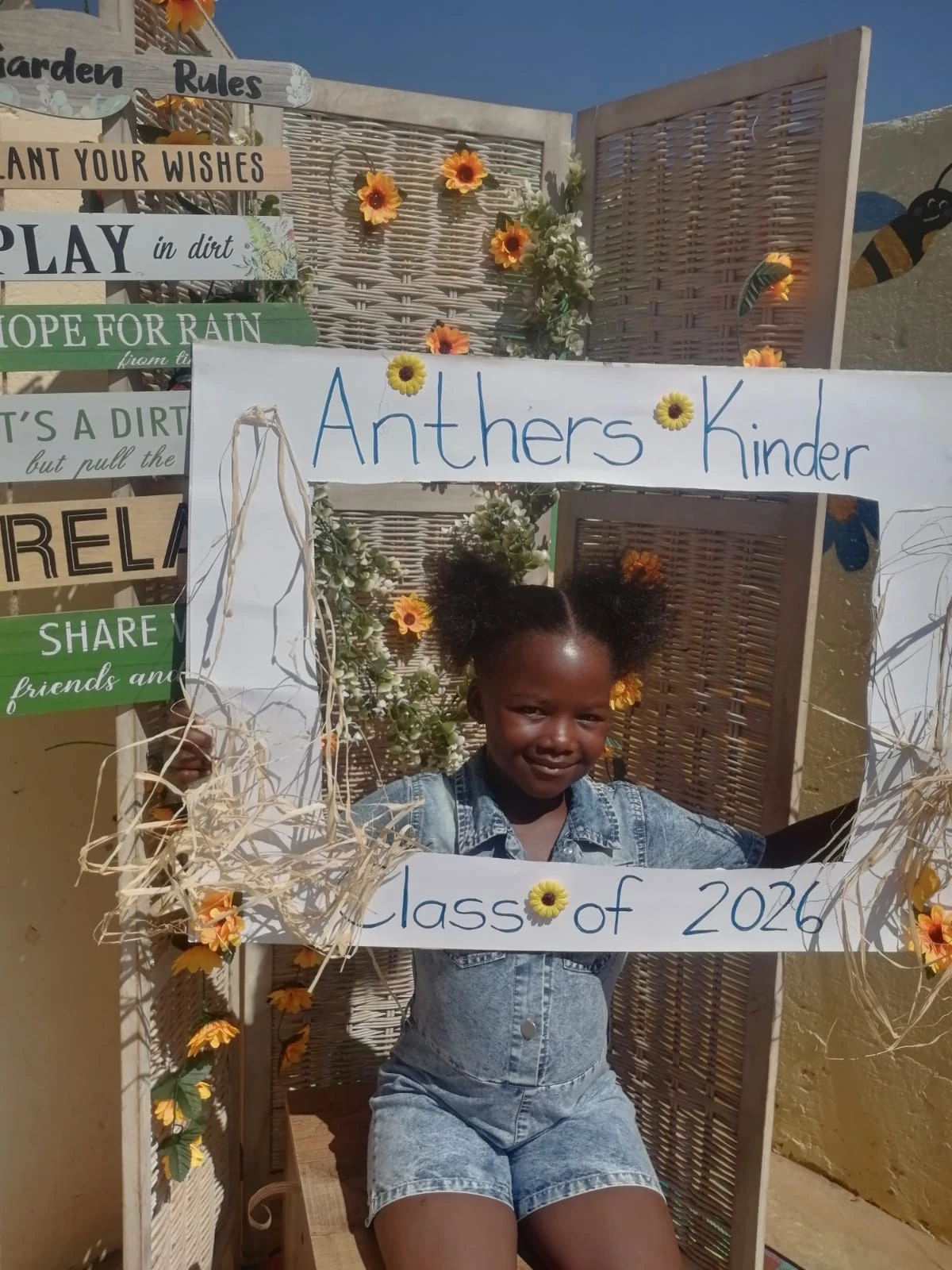 A smiling pupil with flowers around the school celebration frame